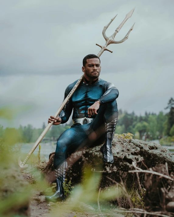 man in blue suit with antlers sitting on a rock