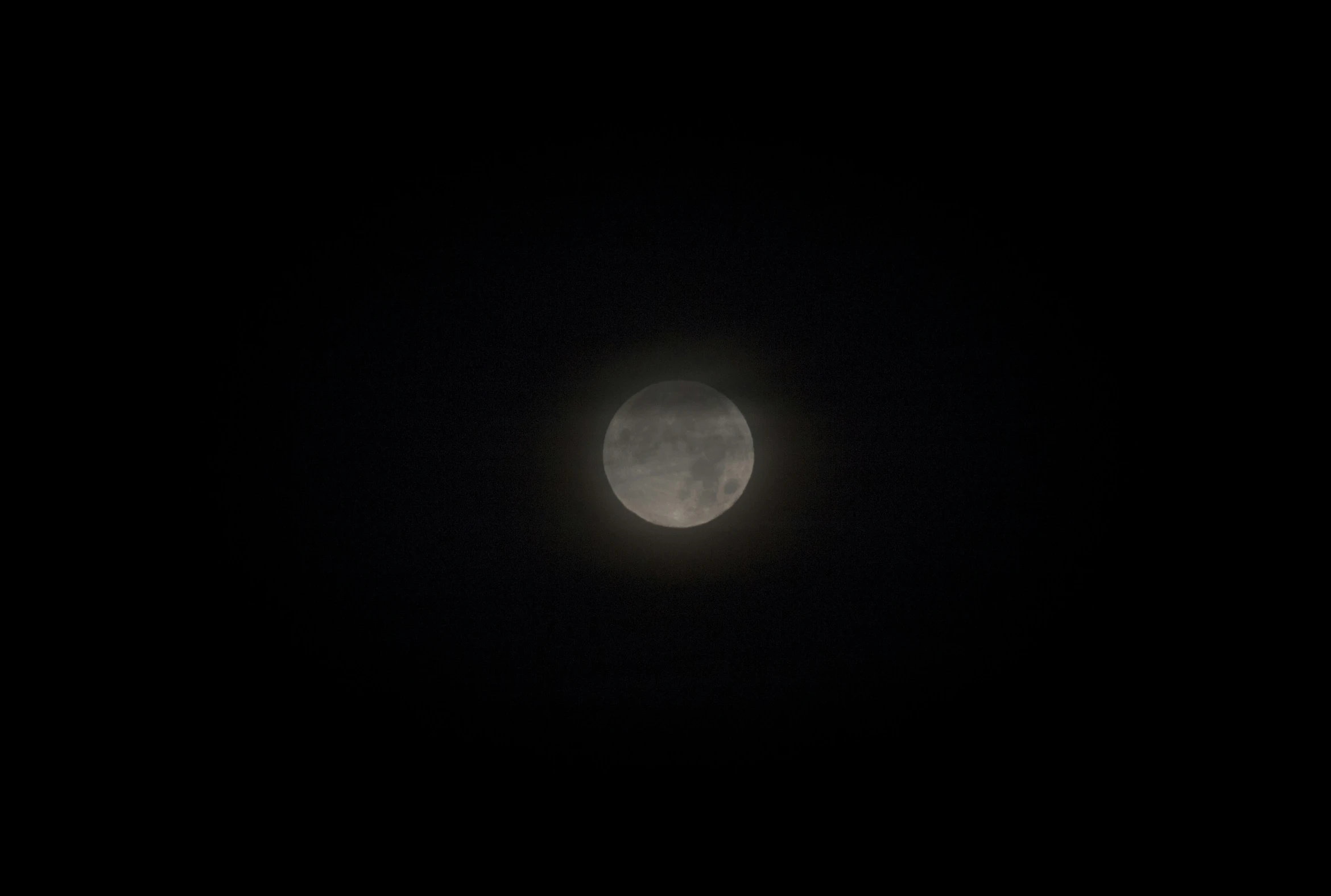 a bright moon in the dark sky on a clear night