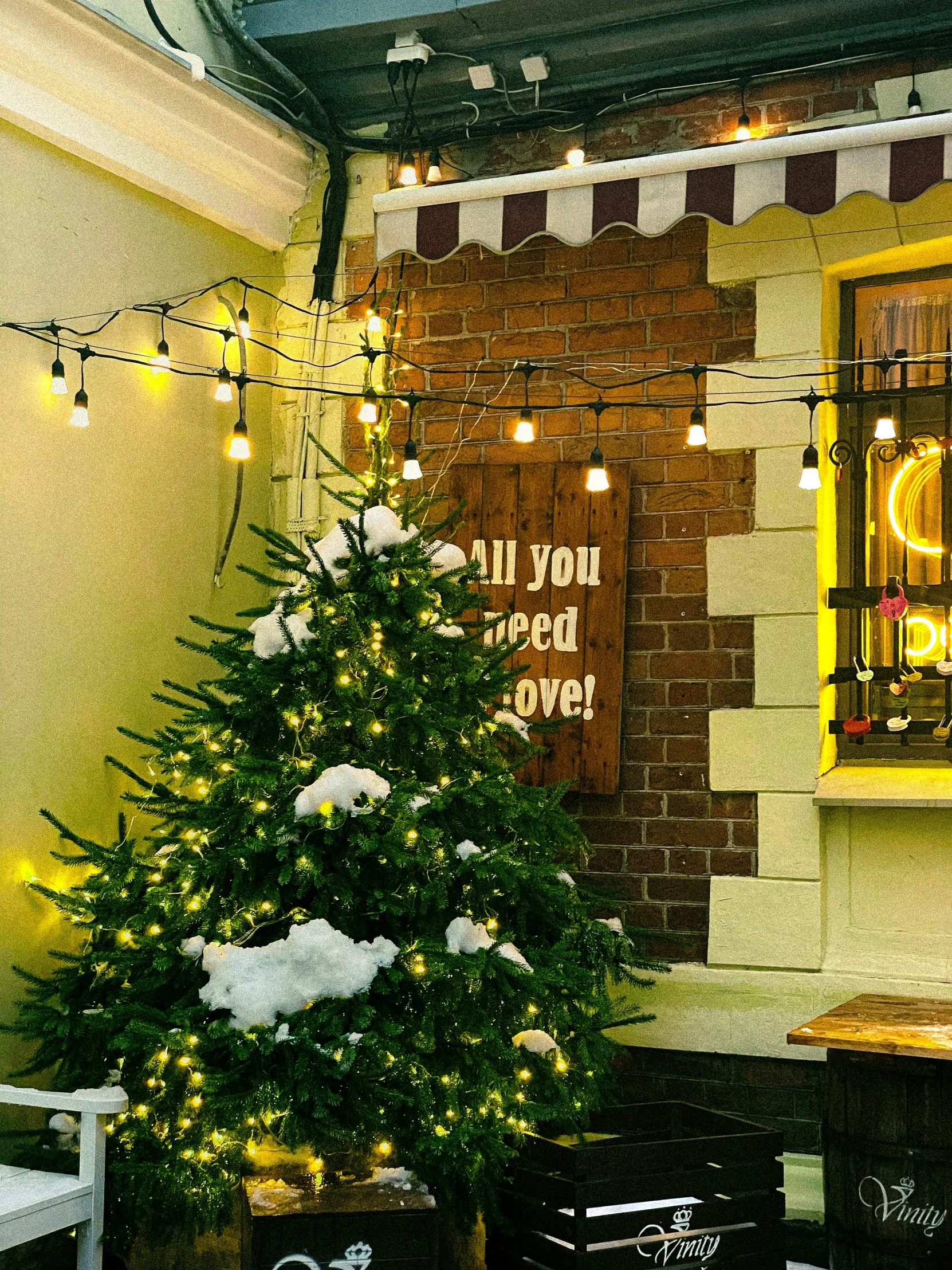 a christmas tree outside a cafe with lights on