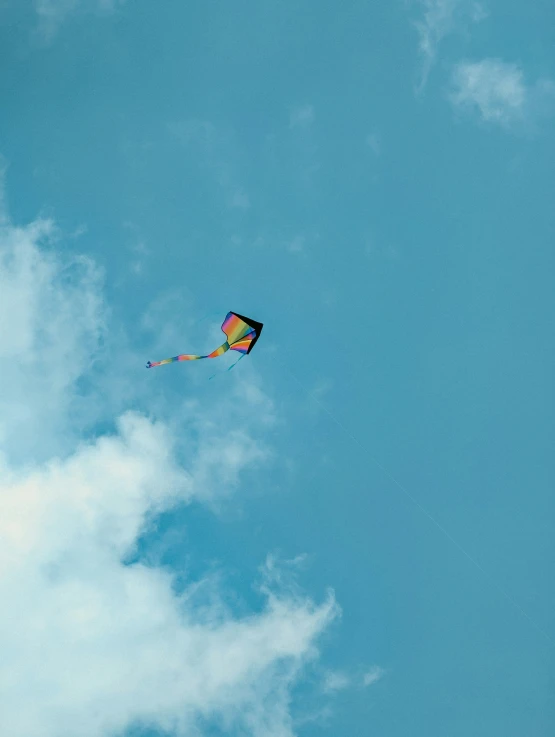 a very colorful kite in the sky with a long tail