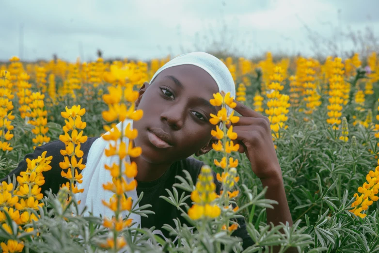 a woman poses in a large flowered field