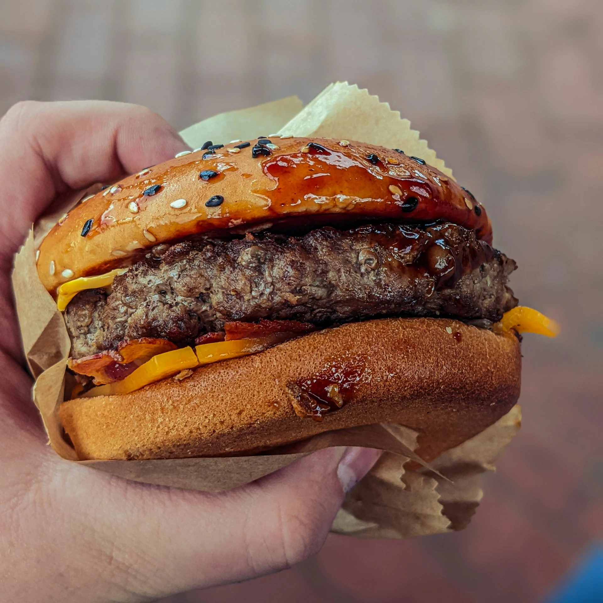 a burger with cheese, sauce, and bacon