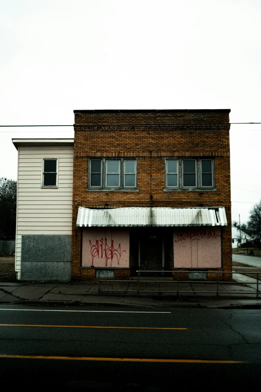 a boarded up building with graffiti on the outside