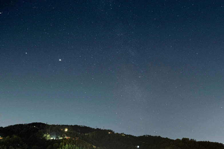 view of the night sky, with mountains and houses all around