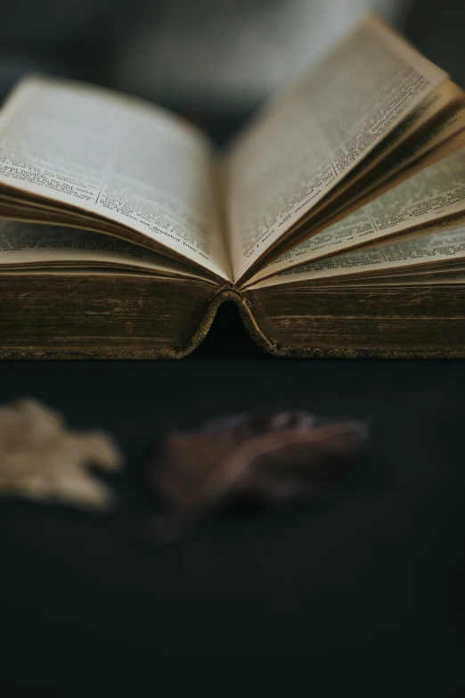 an old book with pages open sitting on a table