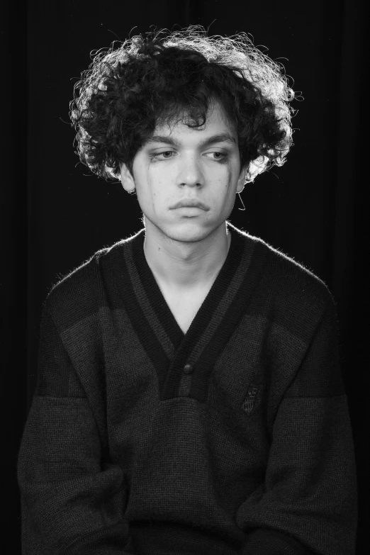 a black and white po of a young man in a curly haircut