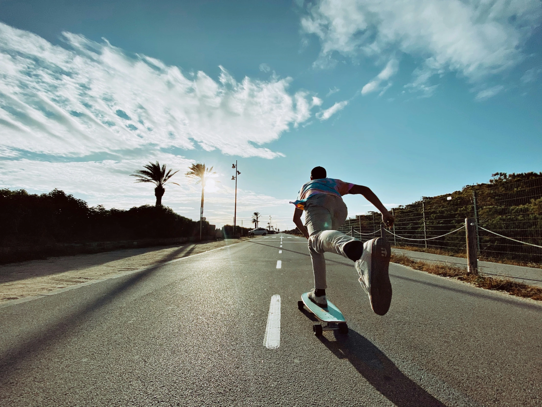 a man riding a skateboard on the side of a road