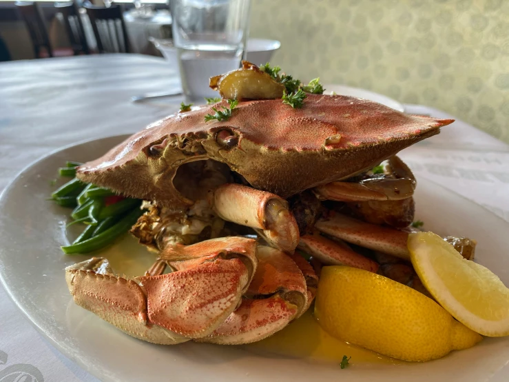 a plate with crab legs, served with lemon slices and lemon wedges
