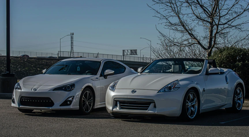 two sport cars sitting in front of each other in a parking lot