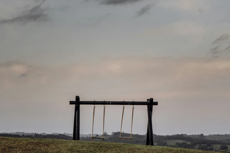 a wooden swing with some swings out front