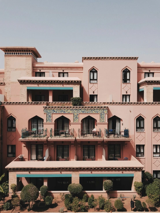 a very pretty pink building with many windows