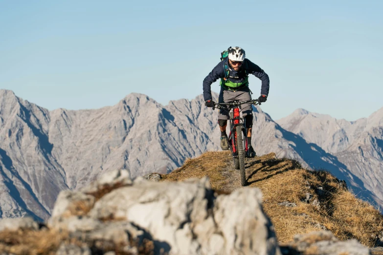 a man riding a bike down a rocky cliff