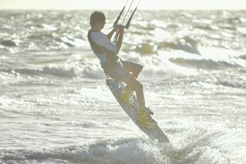 the man is windsurfing through some choppy water
