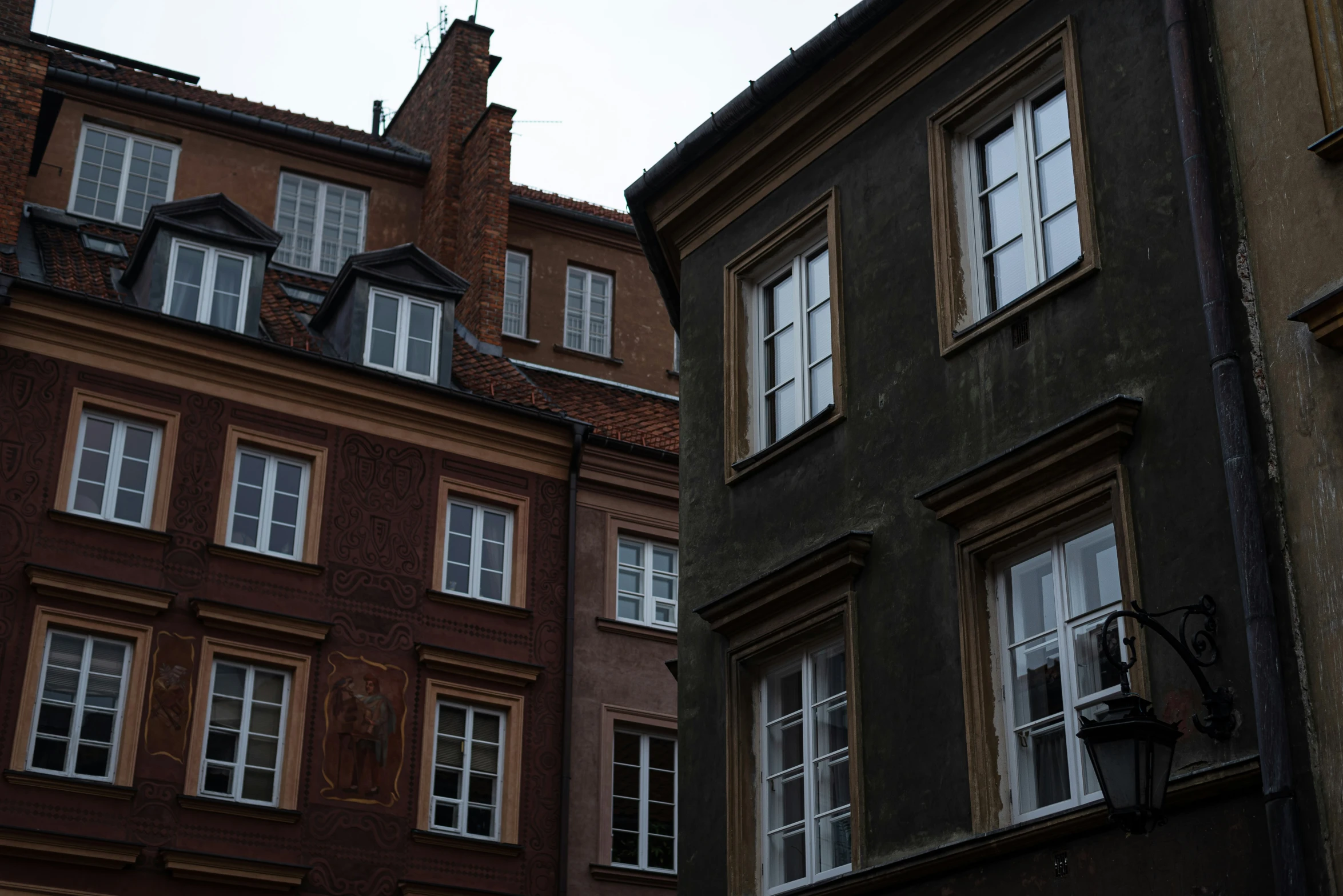 two tall brown buildings with windows and a clock