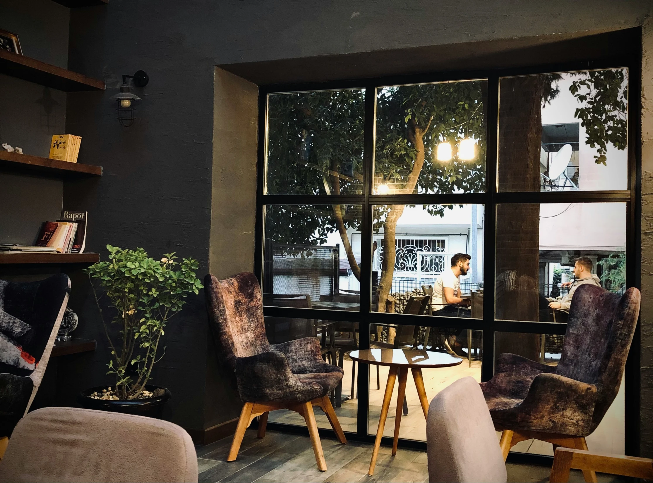 a view of a table, chairs and shelves through a window