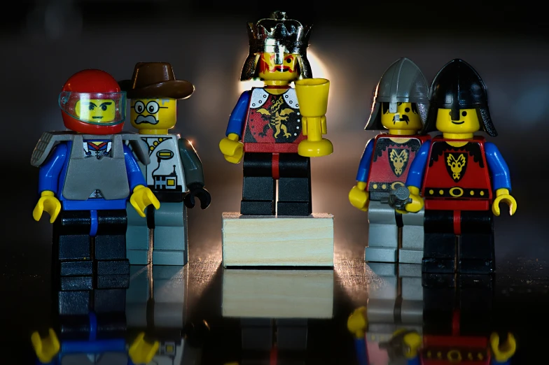 four legos in costumes on a shiny surface