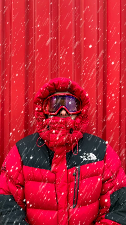 the person wearing the red jacket and goggles