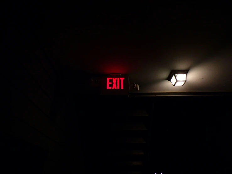 a red sign and a black lamp on a wall