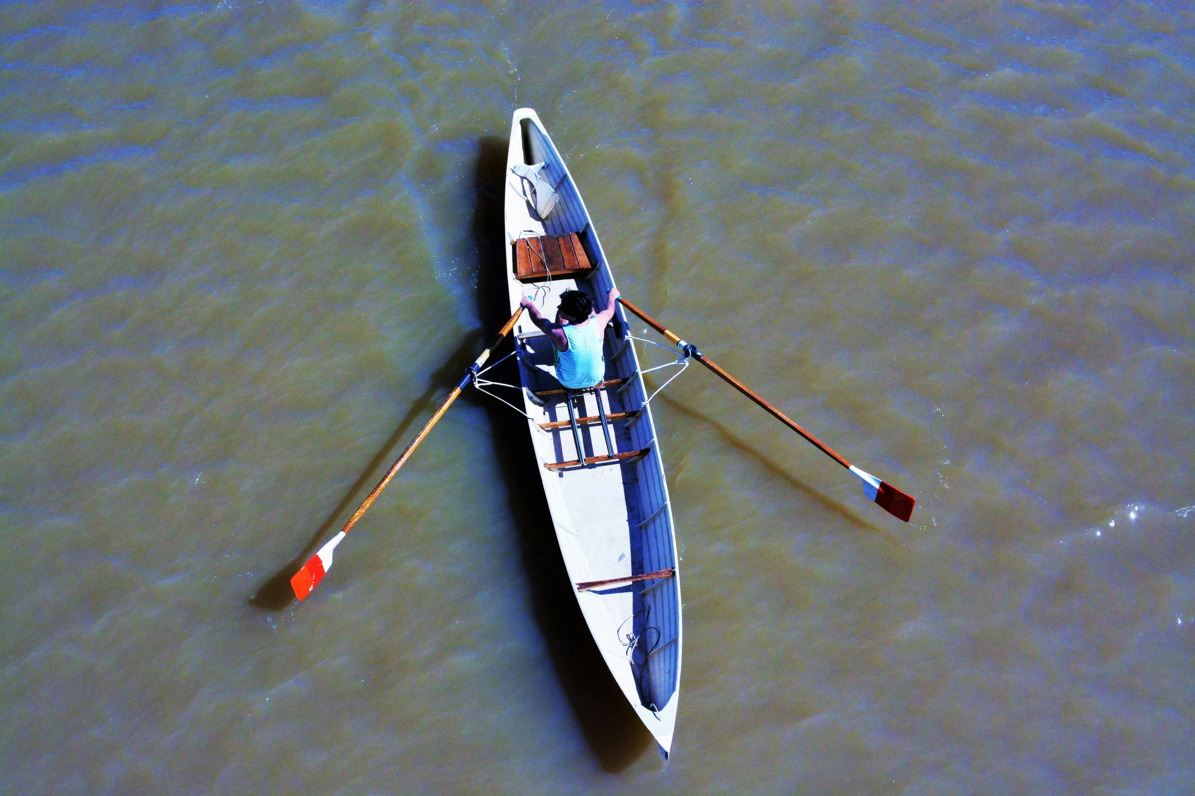 a person rowing a boat on top of a river