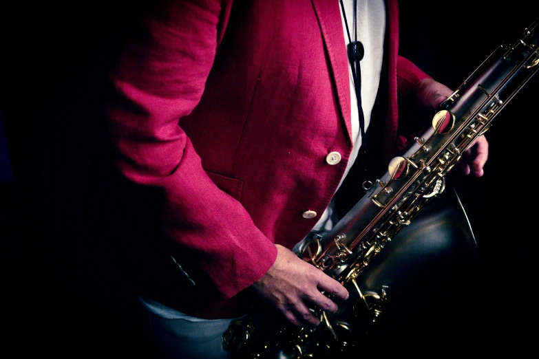 a man wearing a red jacket playing the saxophone