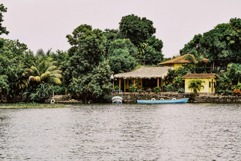 a house on the side of a lake surrounded by trees