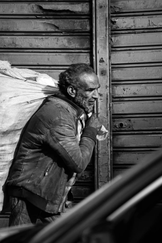 black and white po of a man holding a sack of stuff