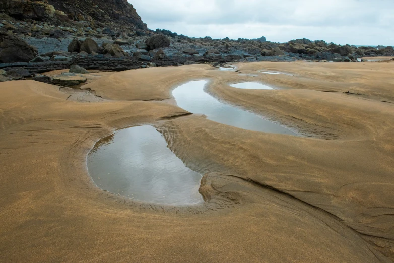 a wet creek flows out to the sand