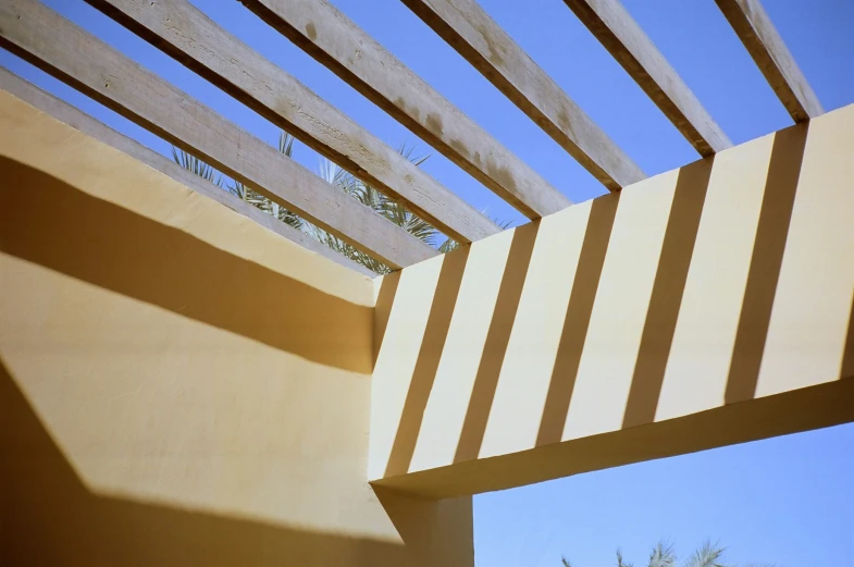 sunlight casts on the structure of a wooden bench