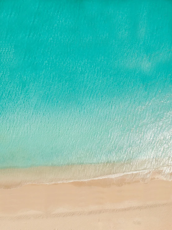 an aerial view of a beach with blue water