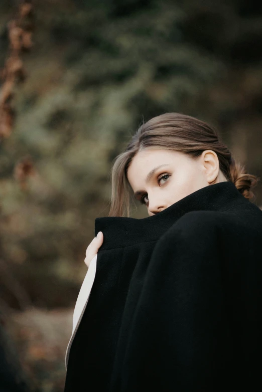 a close up of a woman wearing black cloth on her coat