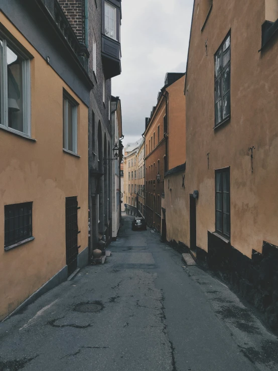 the empty road with cars is pictured near buildings