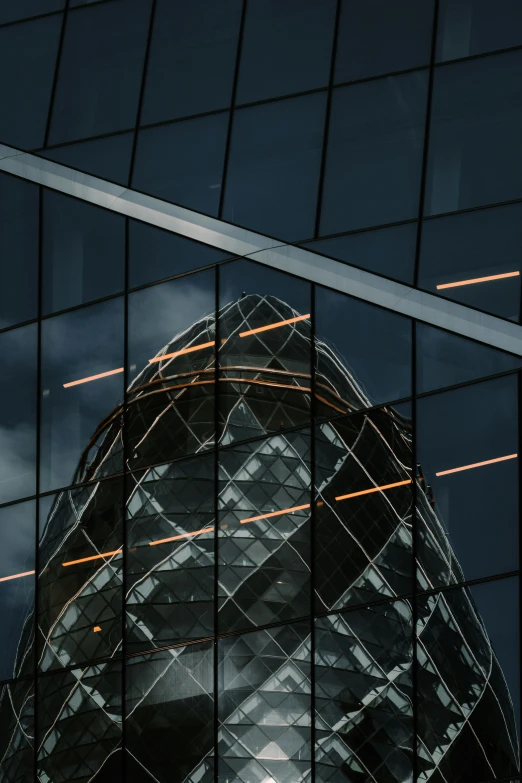 a very tall building reflecting the sky on some glass