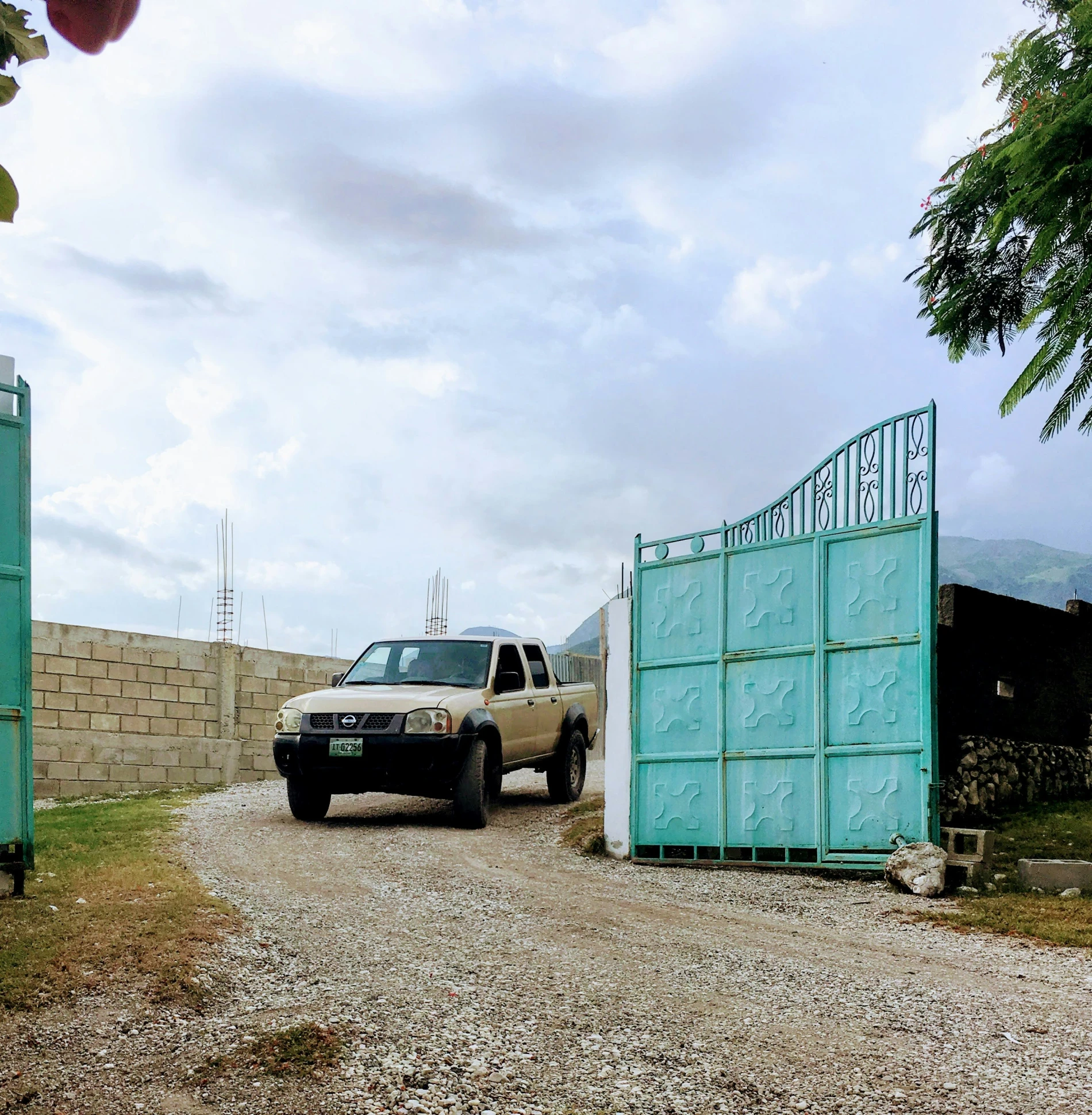 a car is parked outside of a green gate