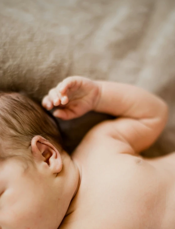 an infant is sleeping on top of a bed