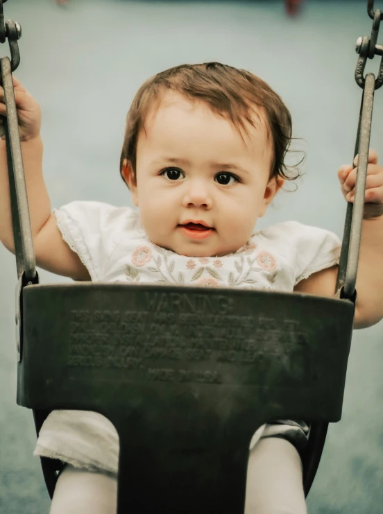 a baby in a swing staring straight ahead