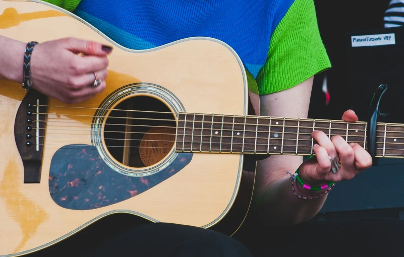 a person is holding a guitar and playing