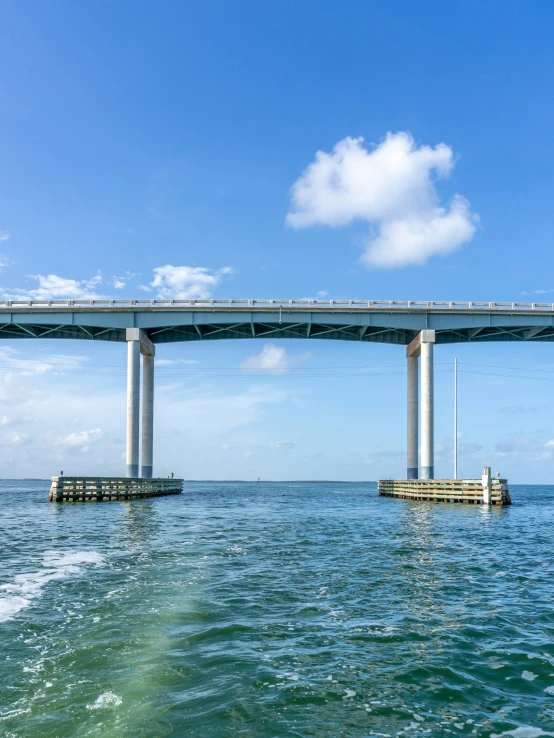 the bridge is above the ocean and has a tower