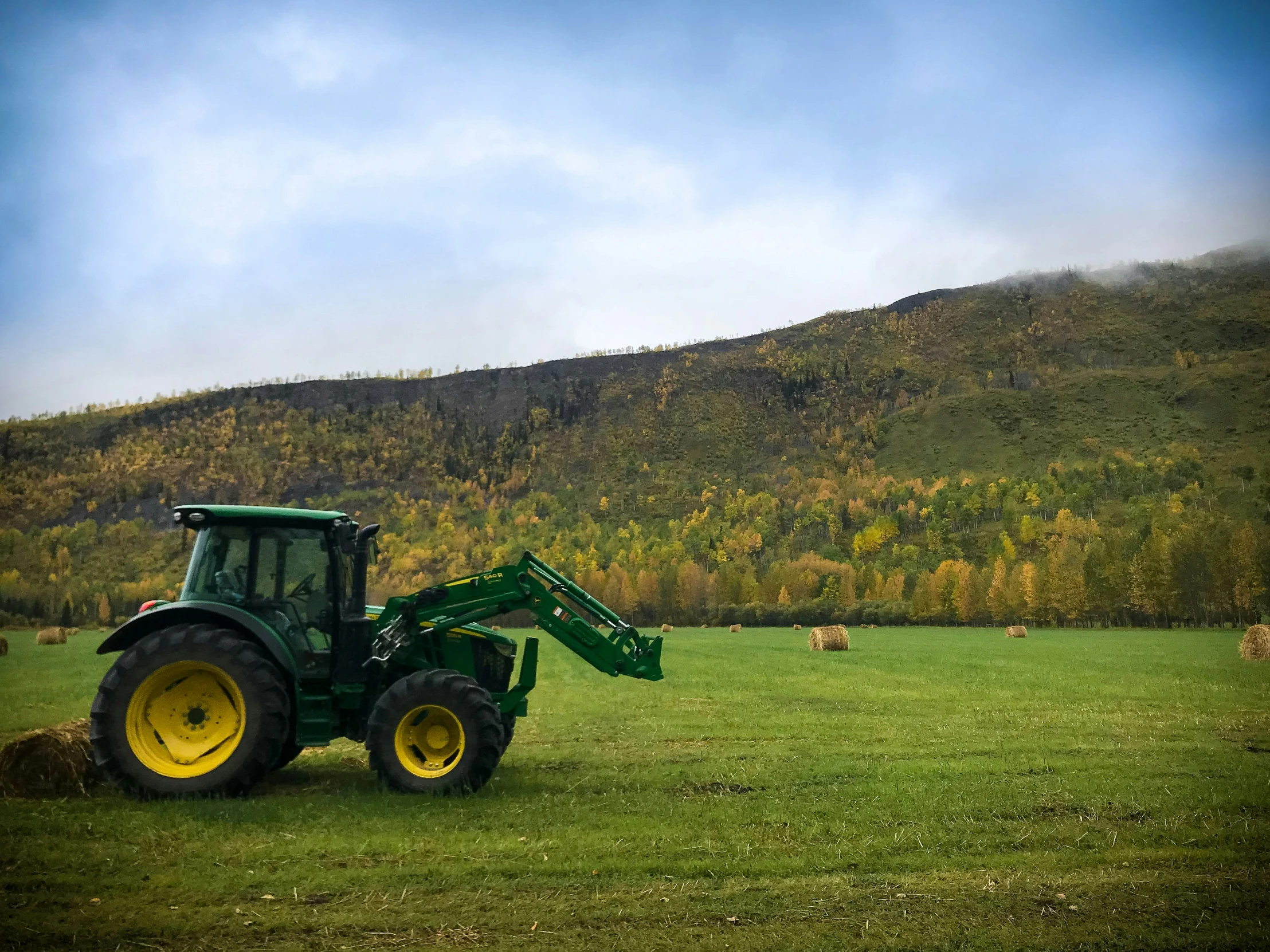 a tractor parked in a field next to a hill