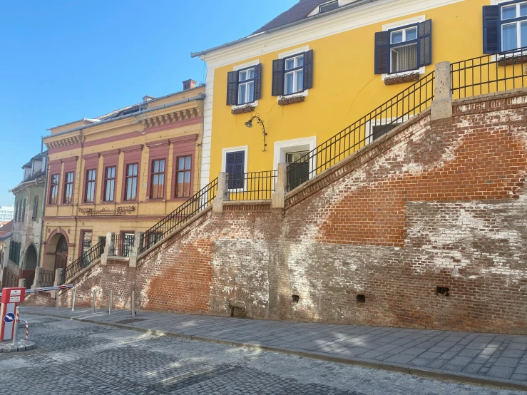 a building on a cobblestone street next to some buildings