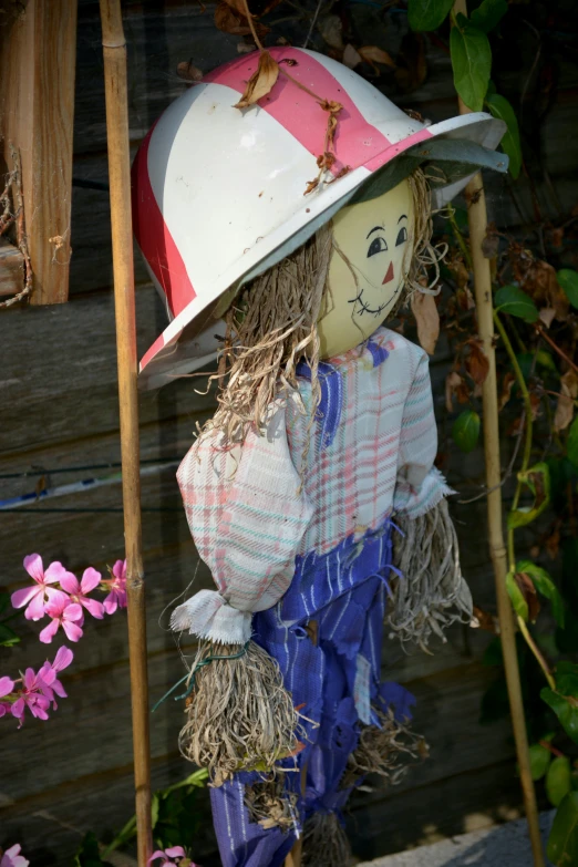 a scarecrow wearing a red and white hat