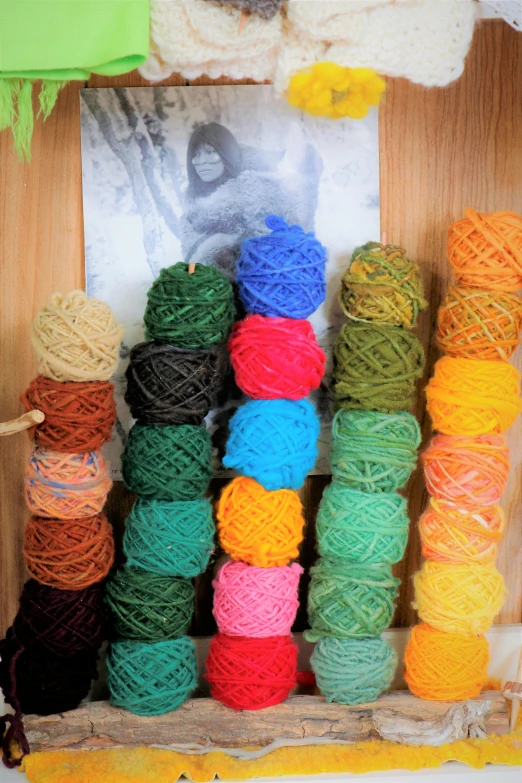 different colors of yarn are stacked on wooden shelves