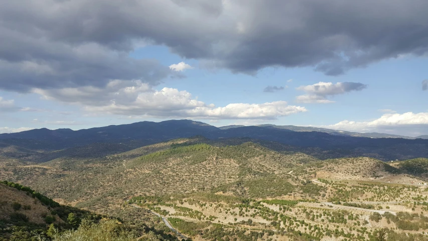 a view from a hill that looks over some hills