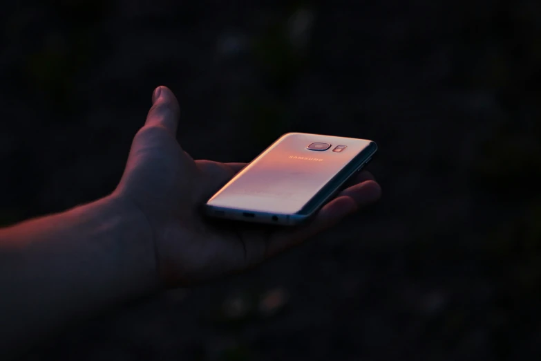 a person is holding a cell phone in their hand