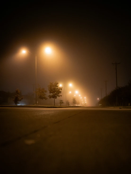 a empty street at night is lit up by street lamps