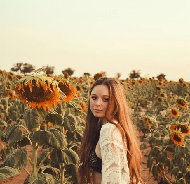 woman in white shirt standing in sunflower field