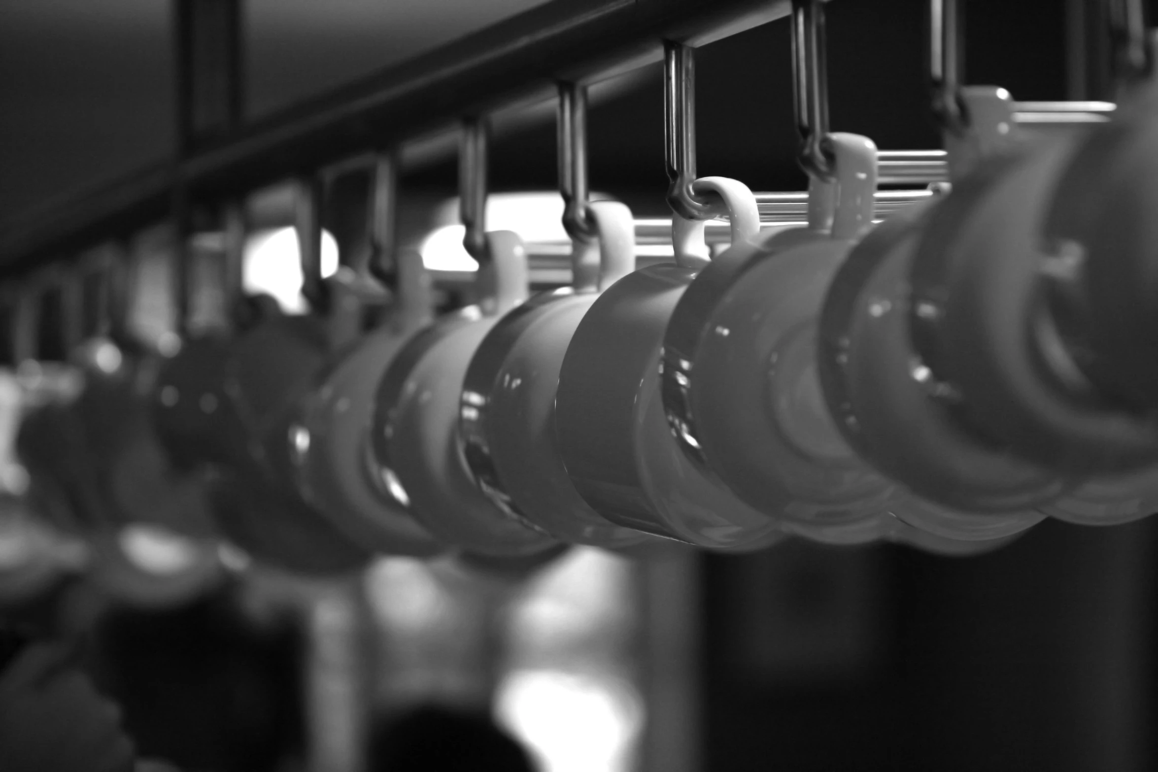 some water cups are hanging on the bar