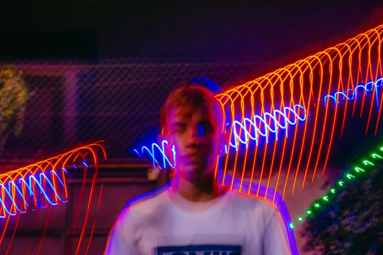 there is a young man standing in front of some lights