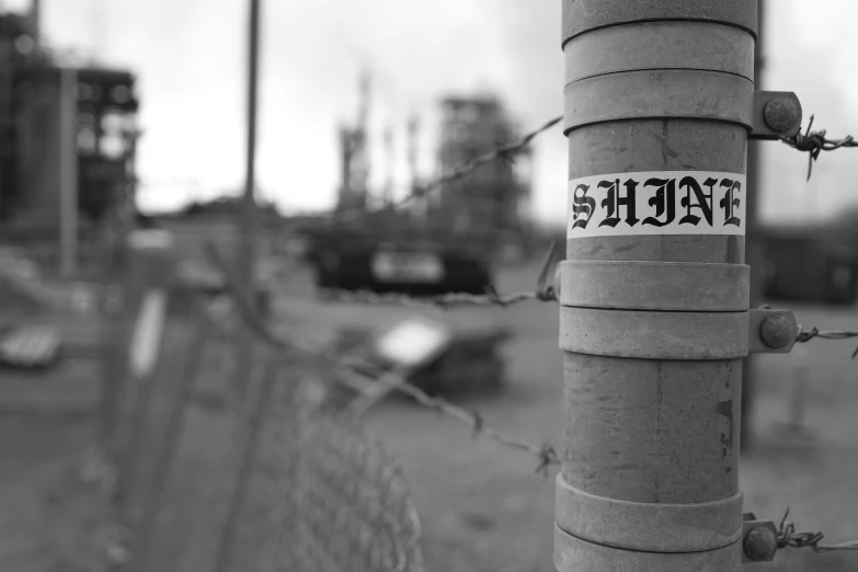 a street sign sticker attached to a metal fence post