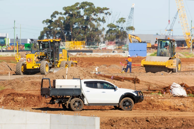 a truck in dirt area next to construction equipment