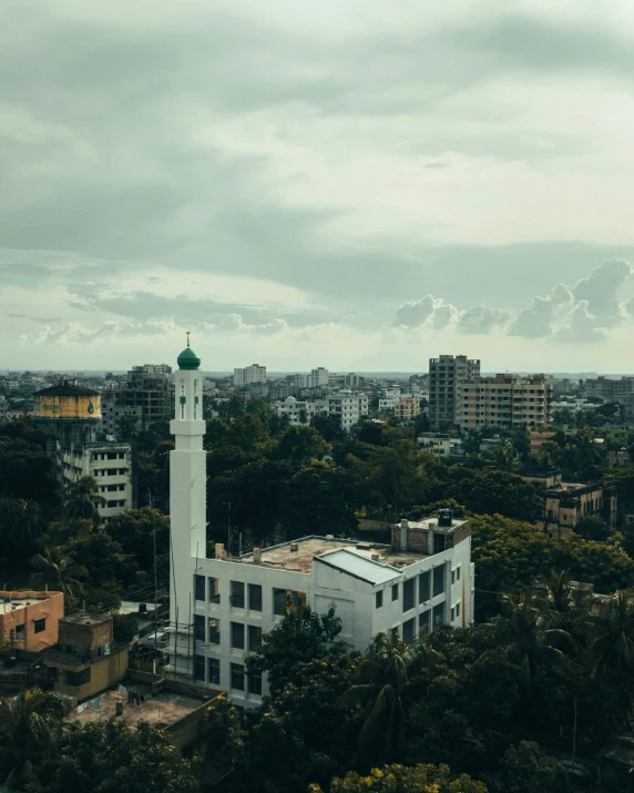 a building with a green dome on top is surrounded by trees and buildings